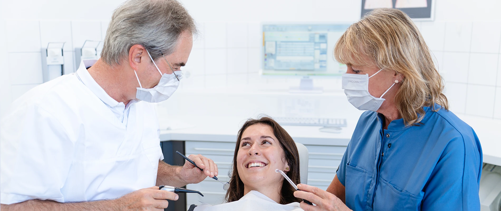 Zahnarzt und Helferin bei der Arbeit